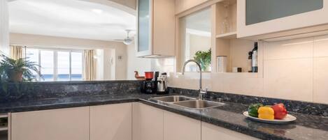 A modern kitchen with a large window, a built-in oven, and a sink.