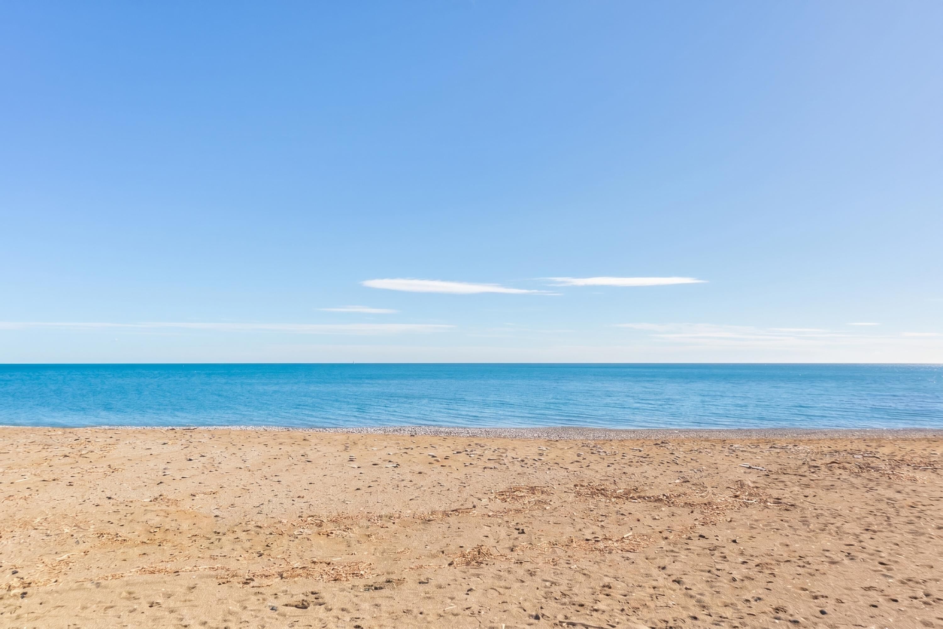 A beach with a clear sky and calm sea.