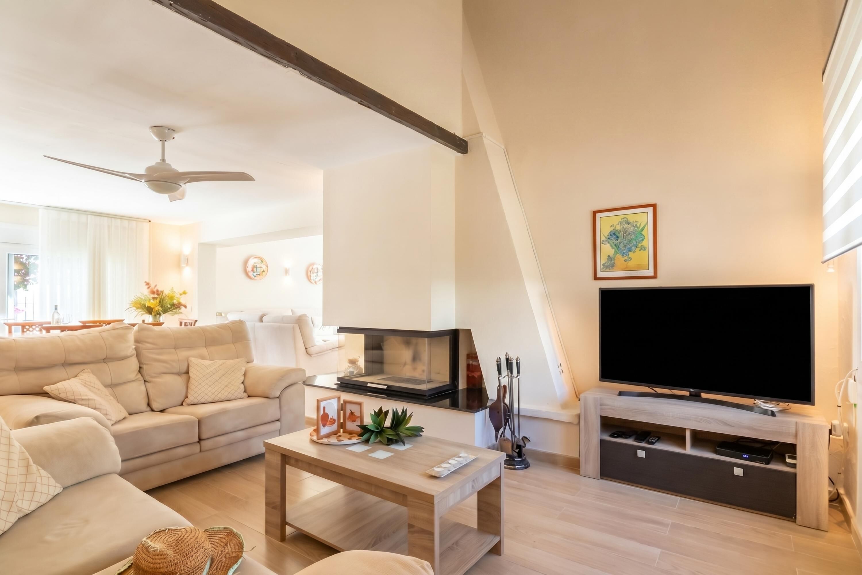 Una sala de estar moderna con sofá, mesa de centro, televisor y chimenea.