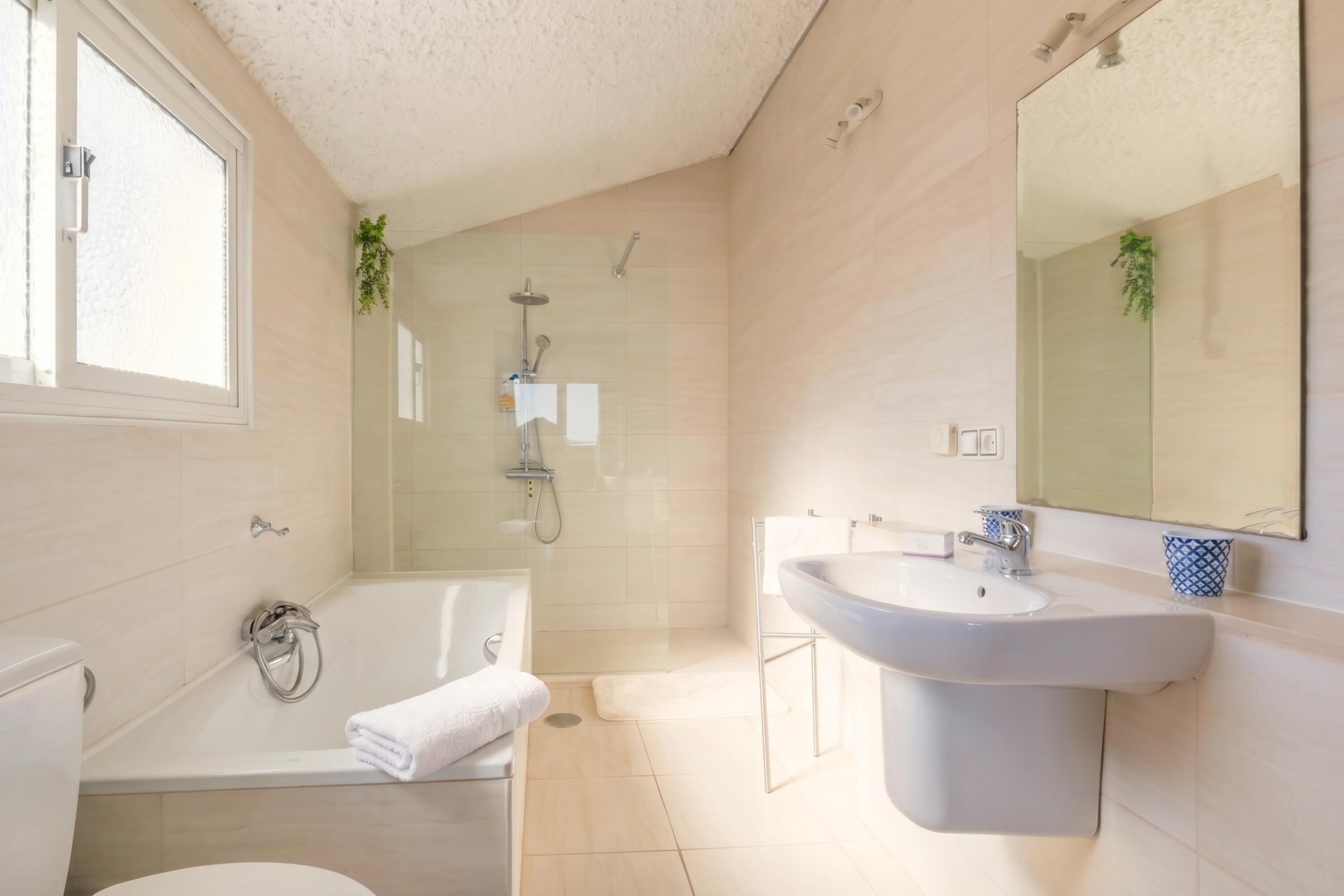 A modern bathroom with a bathtub, a sink, and a shower.