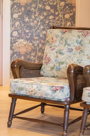 Una silla de madera con tapicería de diseño floral.