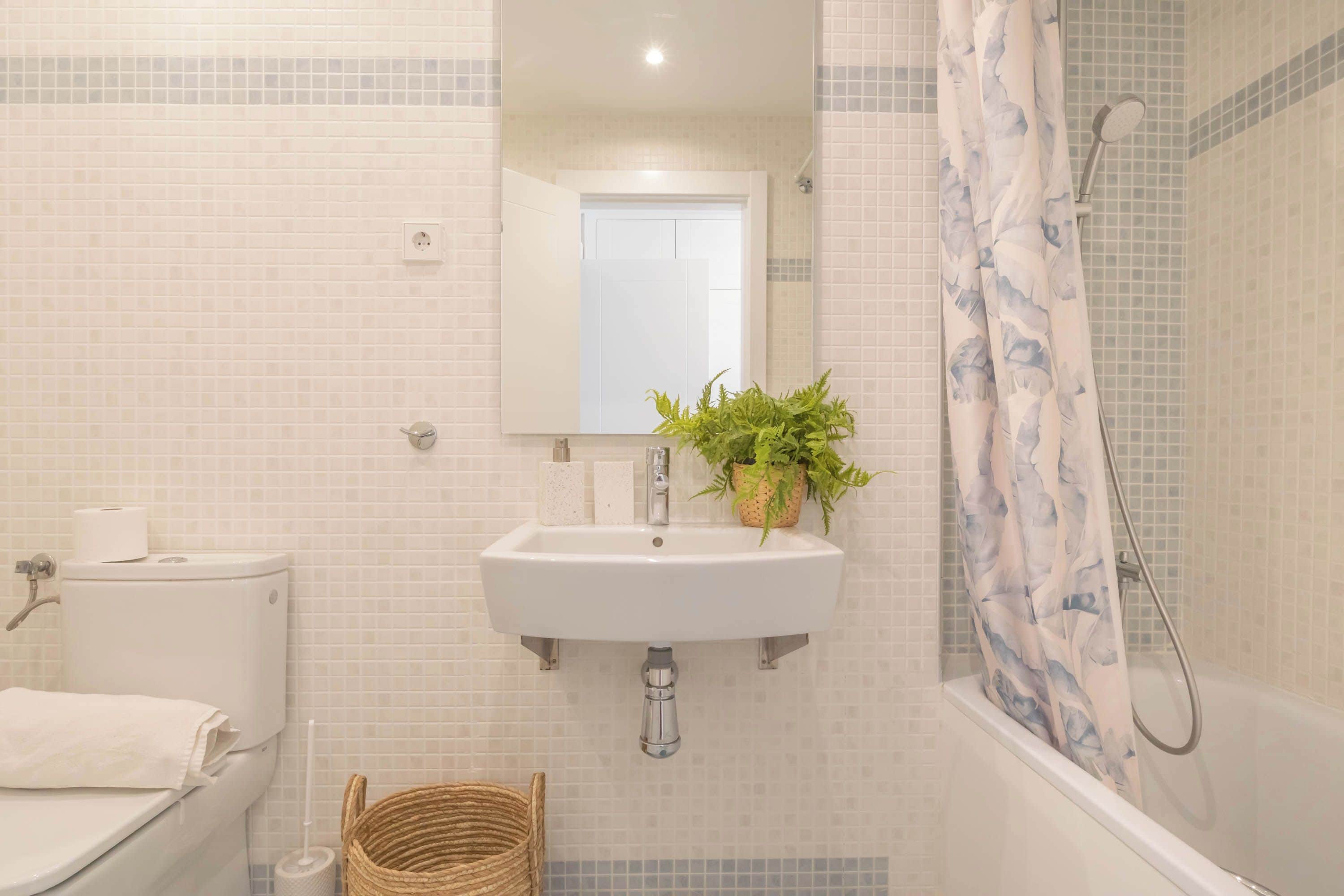 A bathroom with a toilet, sink, and shower.