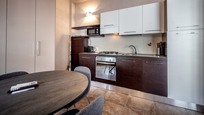 Una cocina moderna con comedor, que cuenta con microondas, horno y electrodomésticos de acero inoxidable.