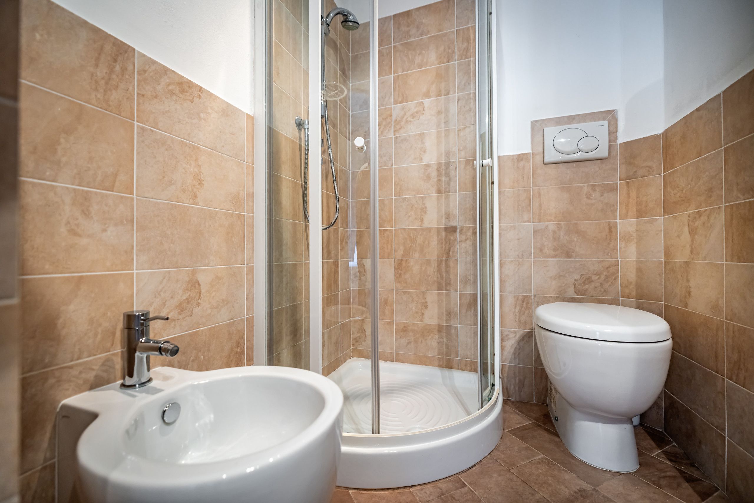 A bathroom with a shower, toilet, and sink.