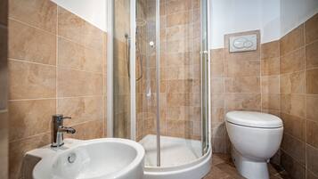 A bathroom with a shower, toilet, and sink.