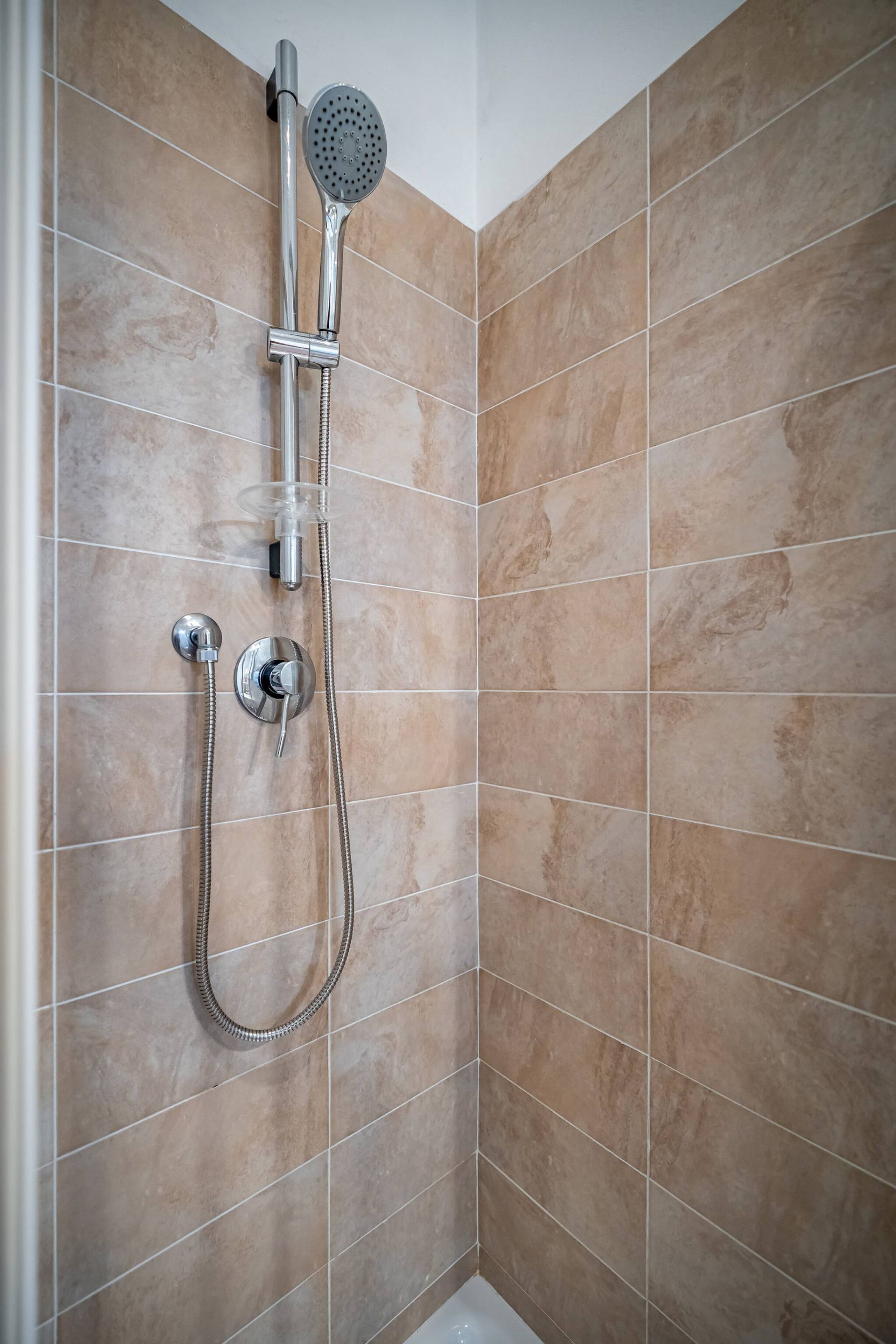 Ducha con cabezal de ducha de mano y grifo empotrado.
