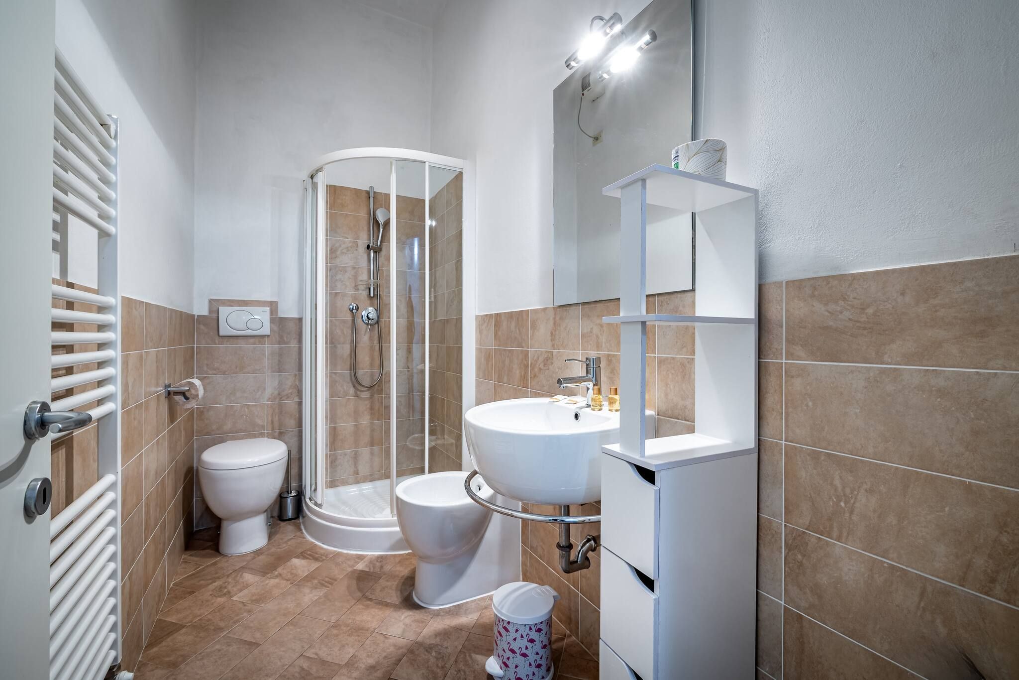 Een moderne badkamer met een douche, toilet en wastafel.
