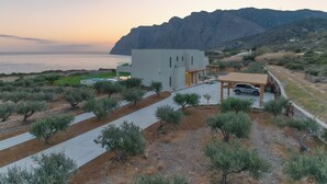 Una villa moderna con piscina, cocheras y vistas al mar y a las montañas.