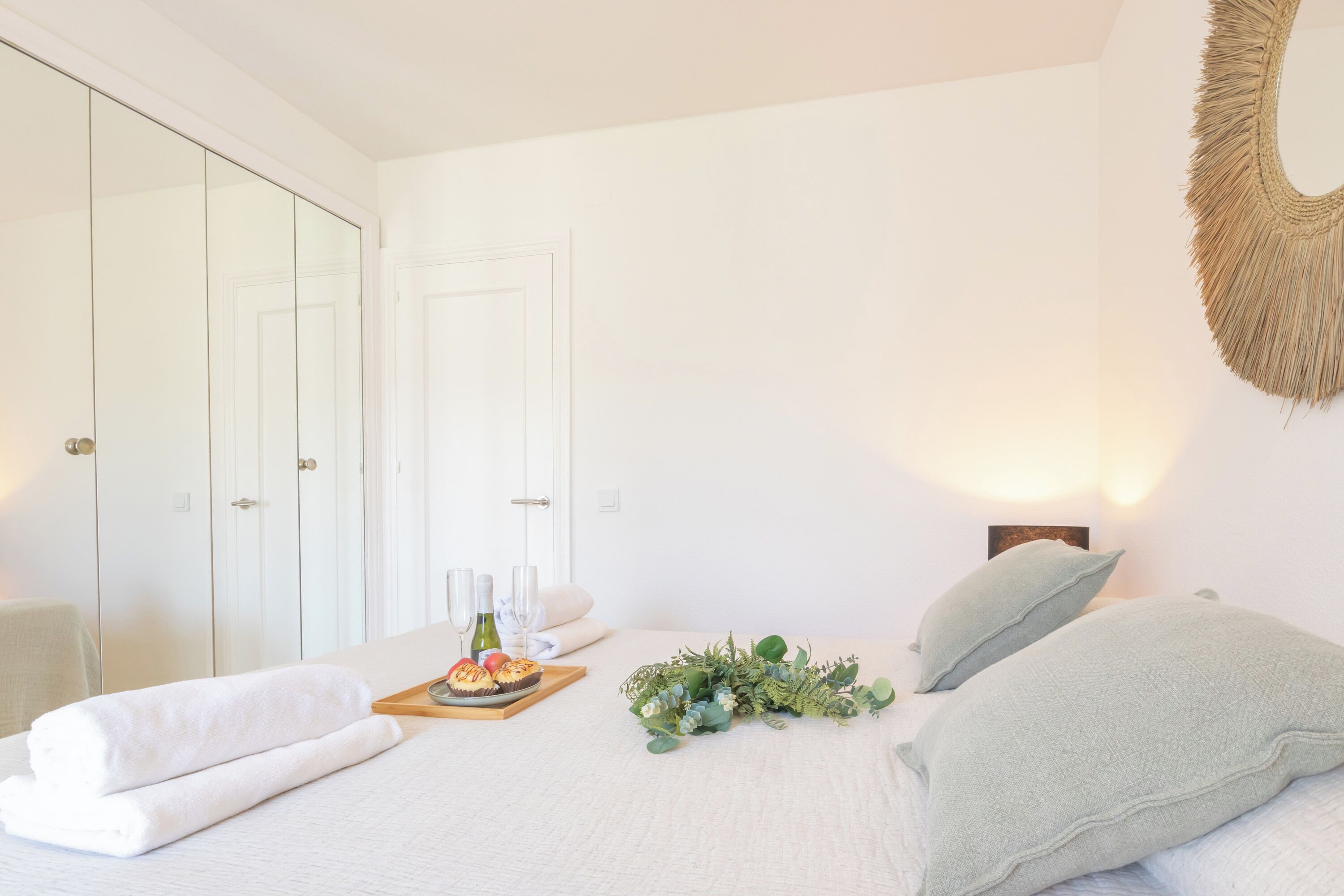 Ein Schlafzimmer mit einem Bett, einem Nachttisch, einem Spiegel und einem Kleiderschrank.