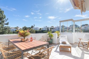 A rooftop terrace with a wooden table, wicker chairs, a cushioned lounge chair, and potted plants. - Calahonda Golf (Mijas)