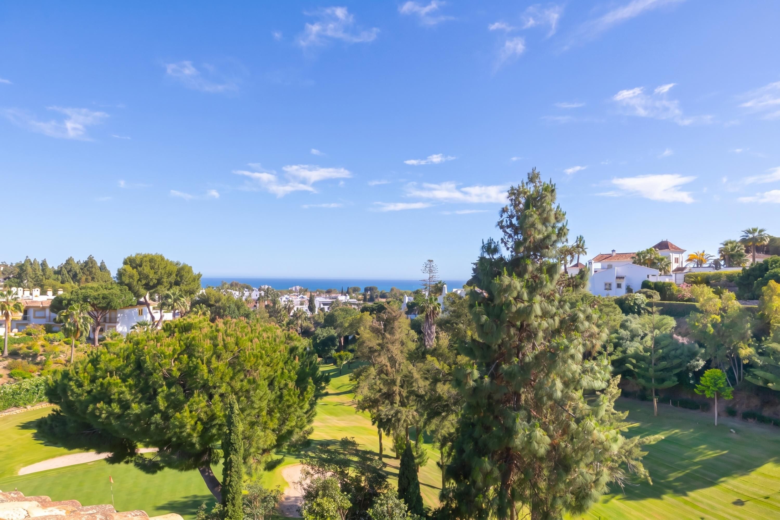 Un parcours de golf offrant une vue sur l’océan, avec des immeubles d’habitation en arrière-plan.