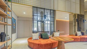 A modern interior with a circular seating area, a wooden coffee table, and a bookshelf. - 360 Paraiso (São Paulo)