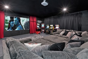 A modern living room with a large gray sectional sofa, a flat-screen TV, and gaming consoles. - LAZY RIVER• Splash park• Pedal boats• Water slide• Theater• Arcades• Volleyball  (Coachella)
