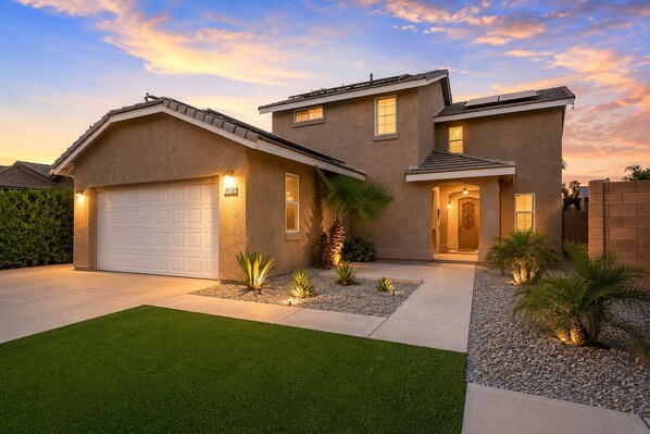 A two-story house with a garage, a well-maintained lawn, and a driveway. - LAZY RIVER• Splash park• Pedal boats• Water slide• Theater• Arcades• Volleyball  (Coachella)