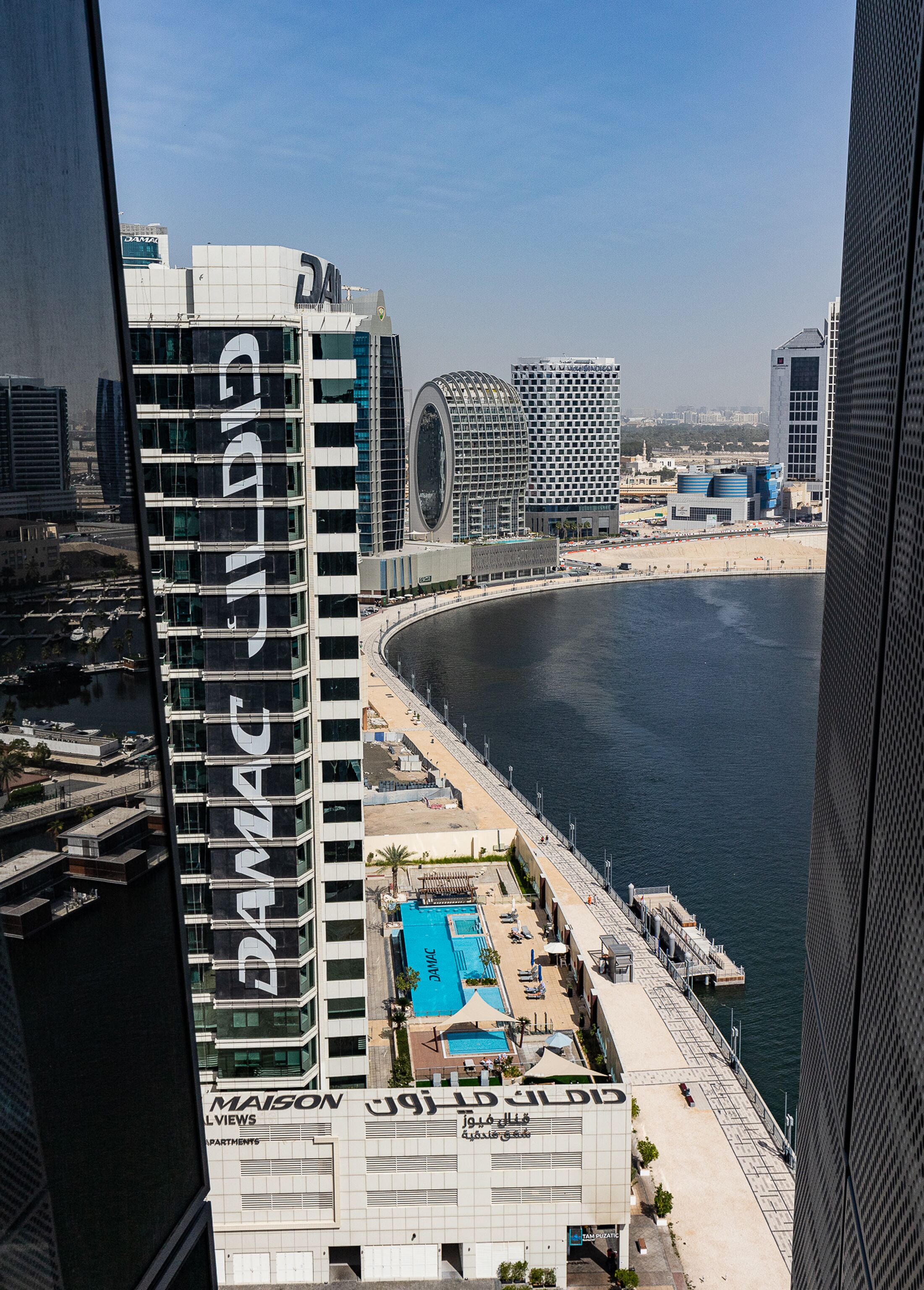 Un hôtel de grande hauteur doté d’une architecture moderne, caractérisé par une façade incurvée remarquable et un espace piscine sur le toit.