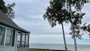 Une maison dotée d’un porche abrité donnant sur un plan d’eau.