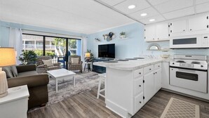 Una cocina moderna con armarios blancos, una isla grande y un horno empotrado.