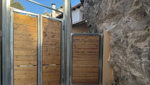 A gated entrance with wooden panels and metal frames, leading to a building with a stone facade. - Classic 3-bedrooms apartment with swimming pool in Meronas (Meronas)
