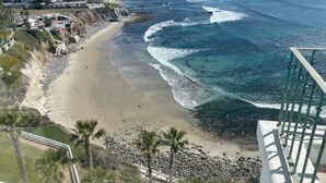 A coastal view with a beach, ocean waves, and a building with a white facade. - Amazing OCEANFRONT Views! 2HUGE Rosarito Condos/Entire Floor! Priv Beach SurfK38 (Playas de Rosarito)