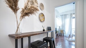 Ein modernes Interieur mit einer Holztheke, zwei schwarzen Barhocker und Wanddekoration.