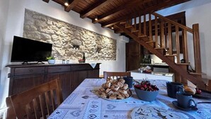 A dining area with a stone wall, wooden staircase, and a table set with food and drinks. - Il Vicoletto Marostica - ITALY (Marostica)