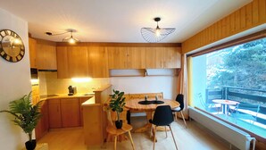 Una cucina moderna con mobili in legno, un tavolo da pranzo con sedie e un'ampia finestra con vista sull'esterno.