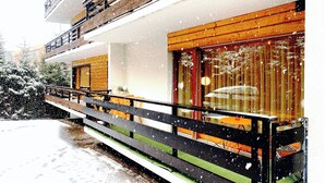 Un edificio moderno su due piani, con un balcone e ampie finestre.