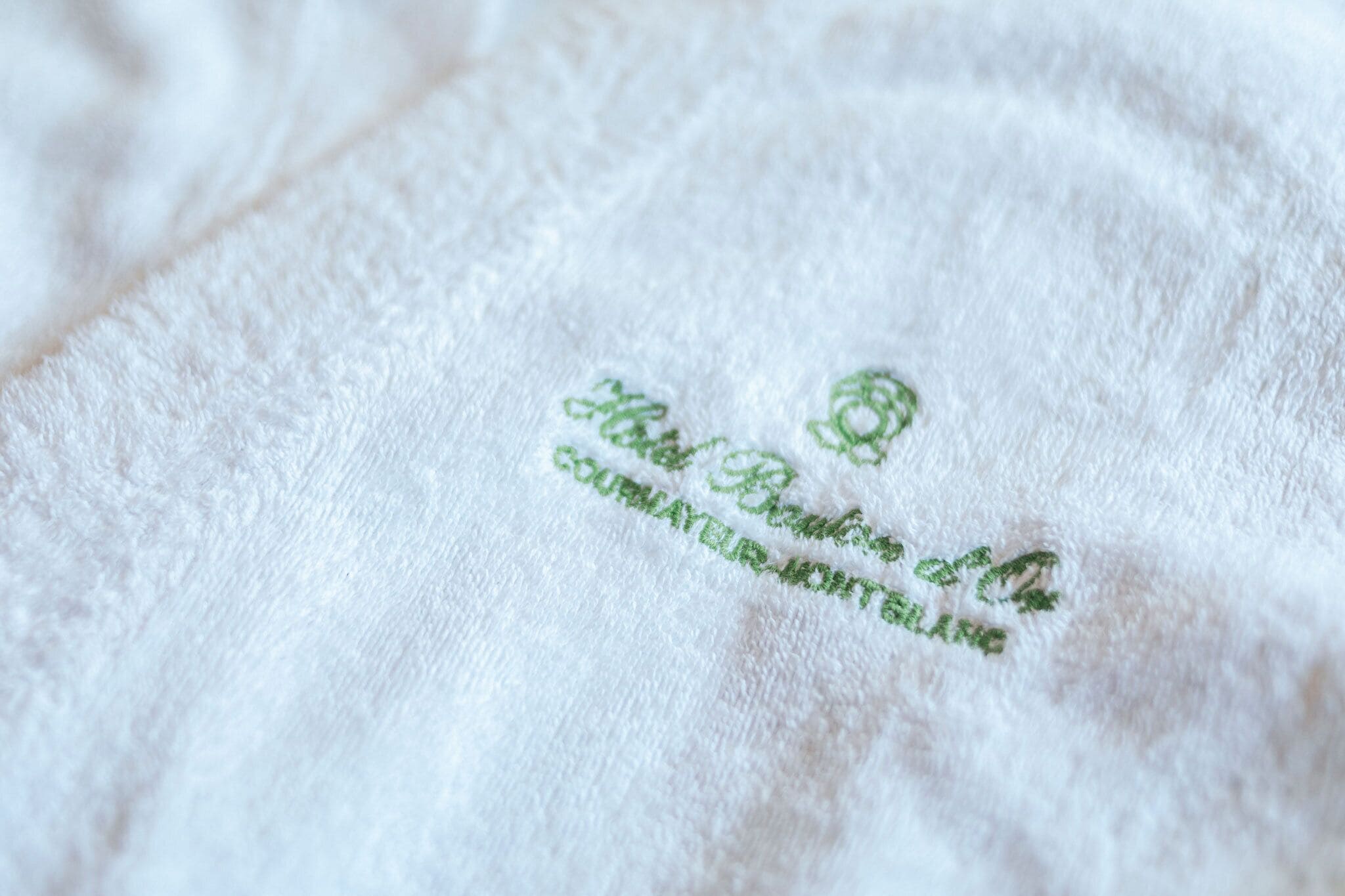 A white towel with embroidered text.