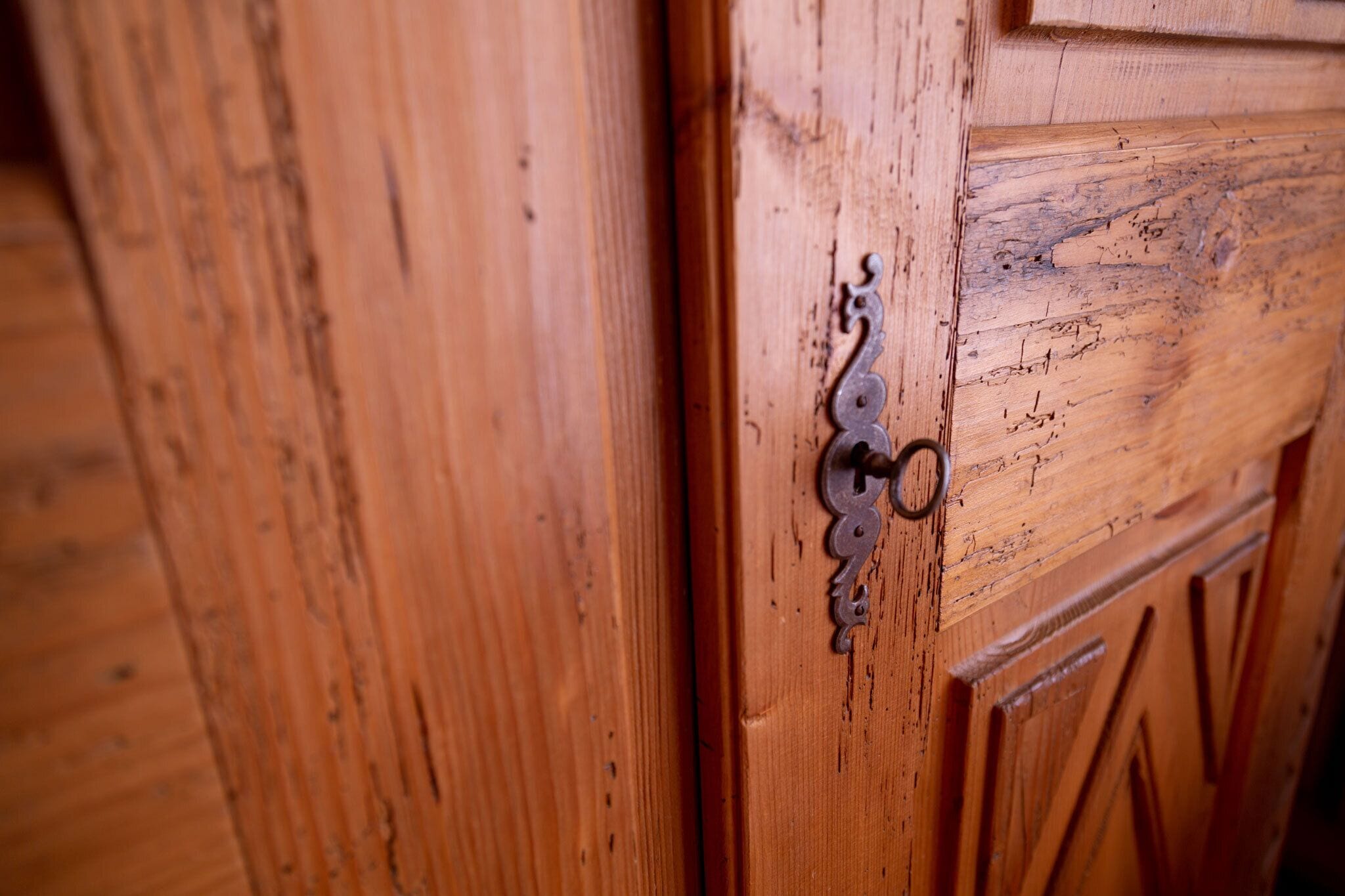 A wooden door with a metal handle and a decorative panel.