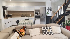 Un espace de vie moderne comprenant un canapé, un coin repas et une cuisine.