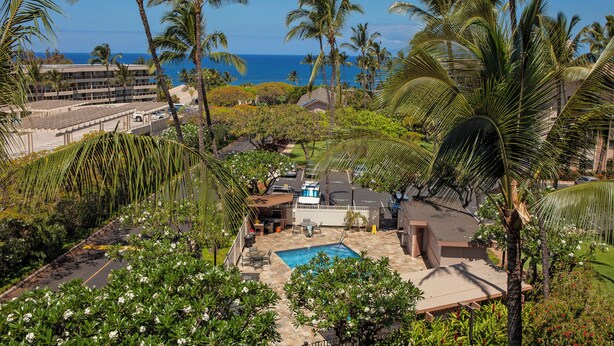 A residential area with a swimming pool, palm trees, and a view of the ocean. - Oceanview Condo | Steps to Kamaole Beach II | Top-Floor Kihei Comfort w/ AC (Kihei)