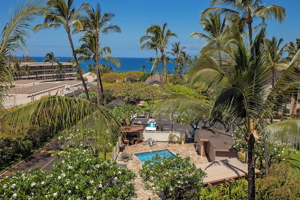 This tropical paradise sits nestled among swaying palms with the sparkling ocean just beyond—a stunning retreat where lush gardens meet endless blue horizons.