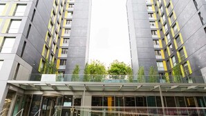 Ein modernes Gebäude mit einer symmetrischen Fassade, großen Fenstern und einem Glasvorbau.
