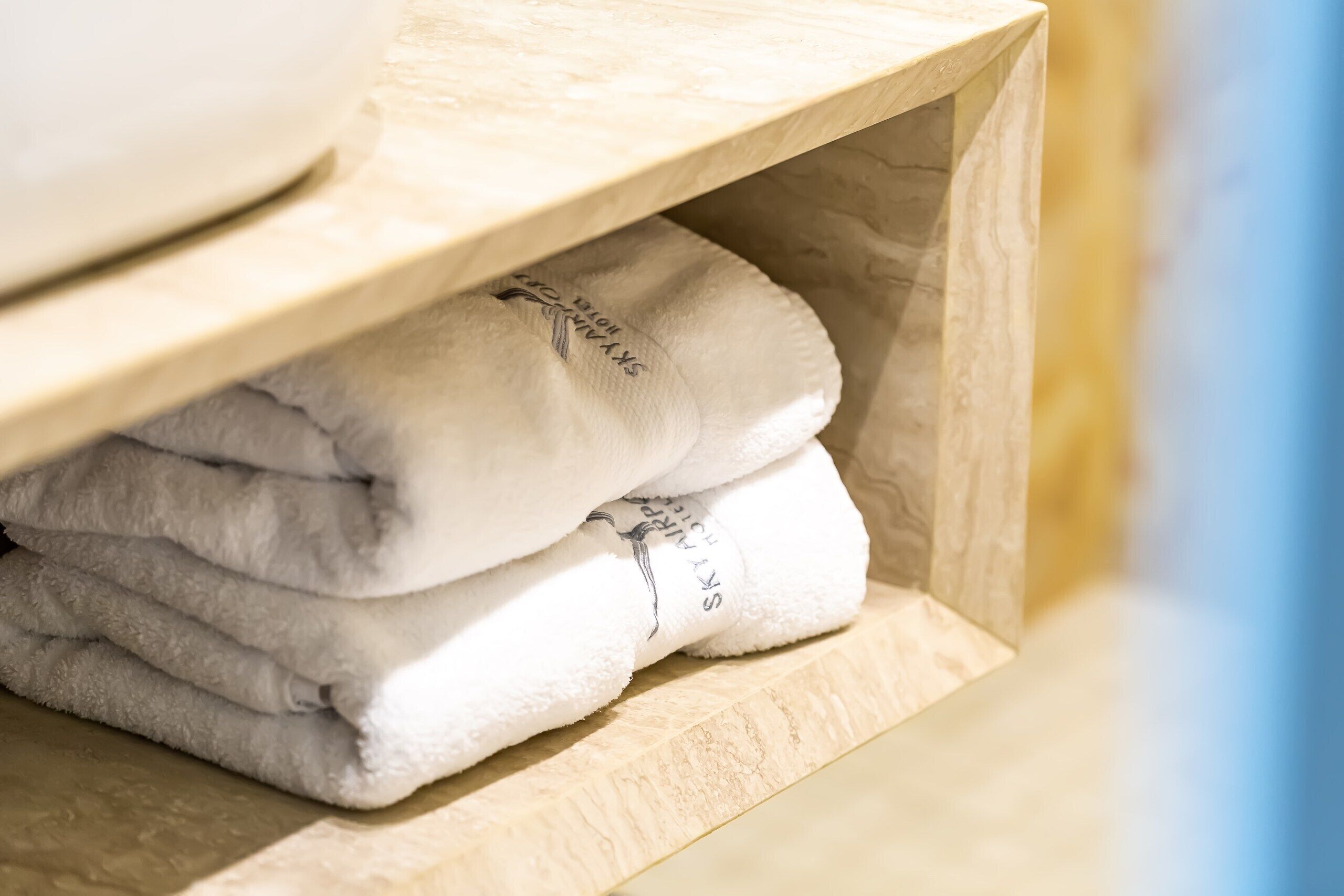 A wooden shelf with folded towels.