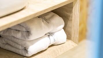 A wooden shelf with folded towels.