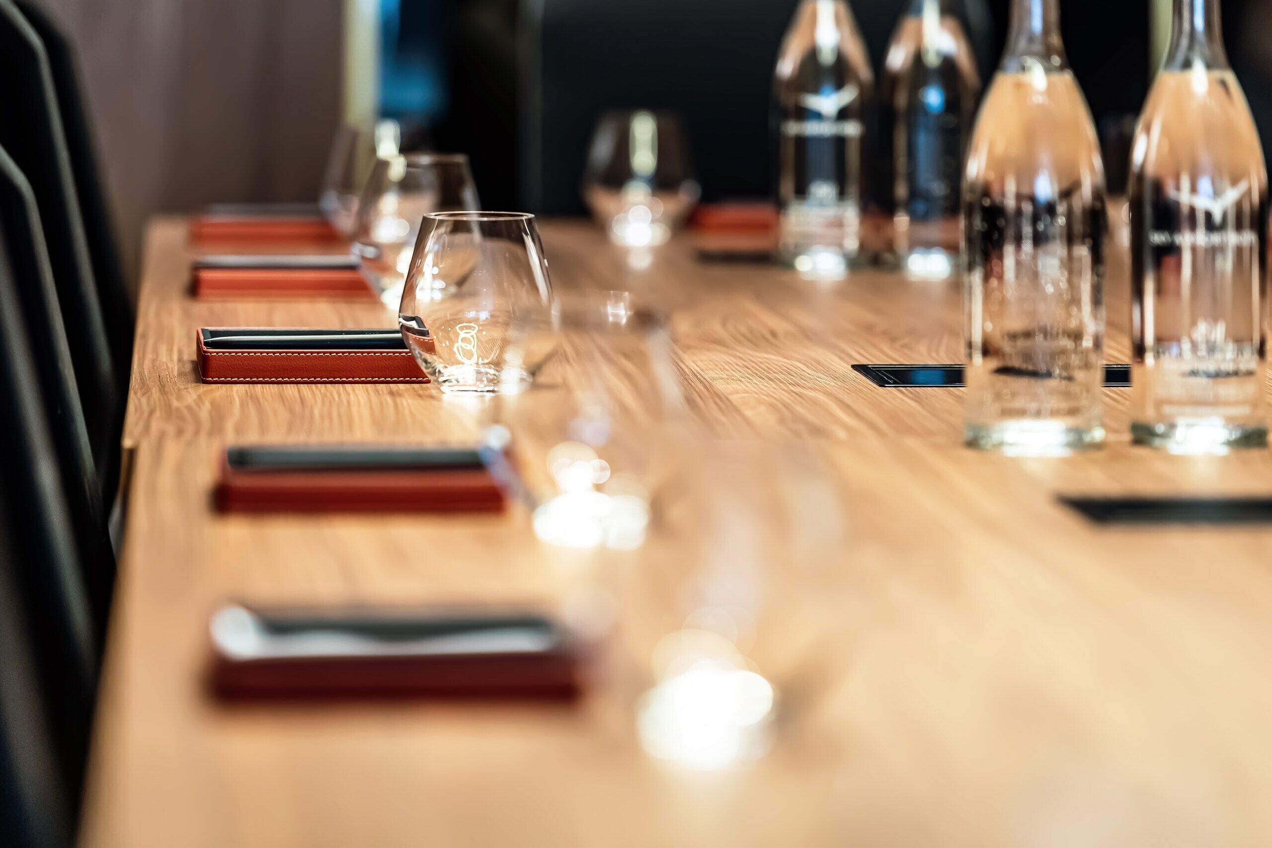 A long wooden table with glasses and bottles, likely in a dining area.