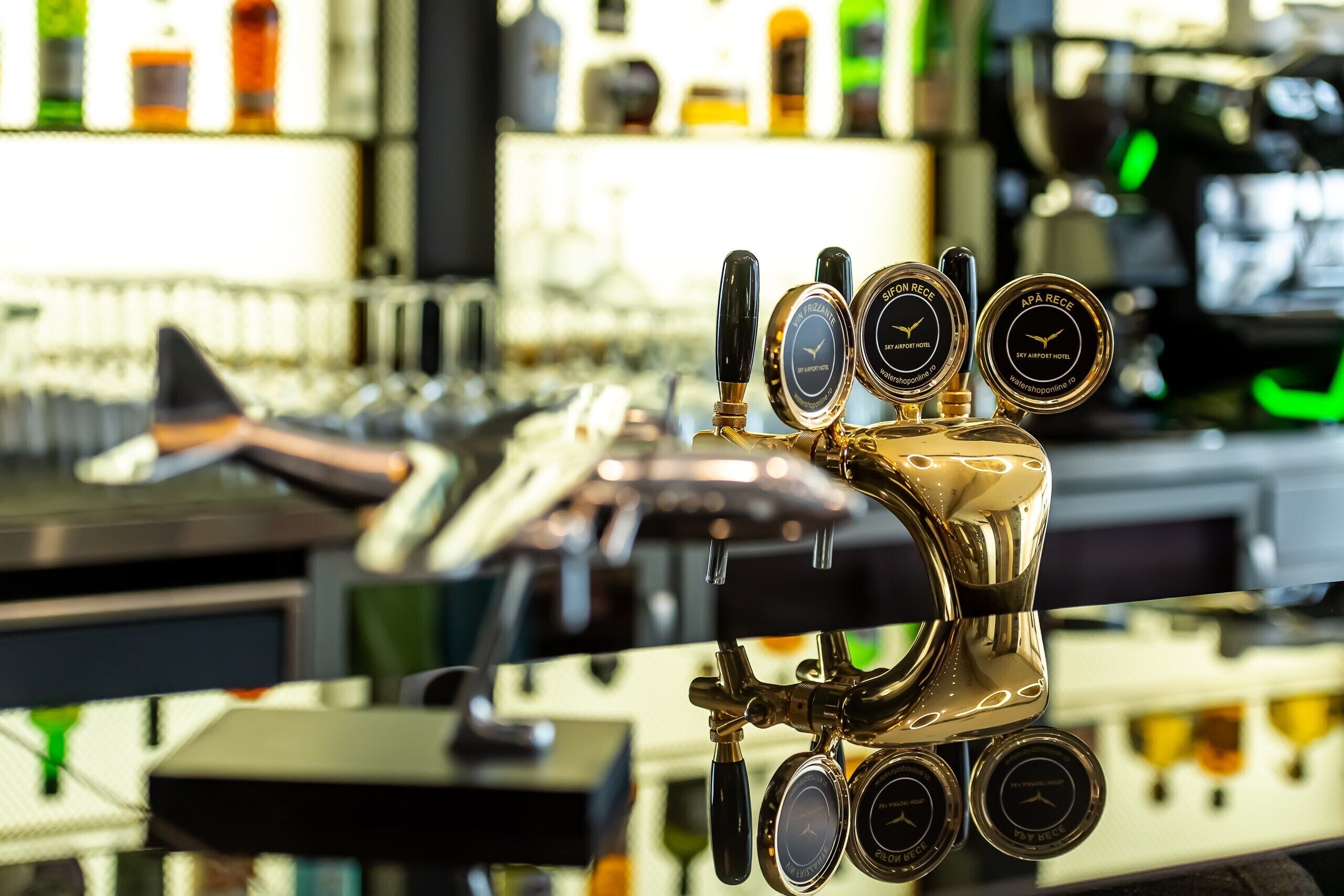 Un área de bar con una llave de cerveza y un grifo etiquetado 'SIP ON RECEC' y 'APA RECEC'.