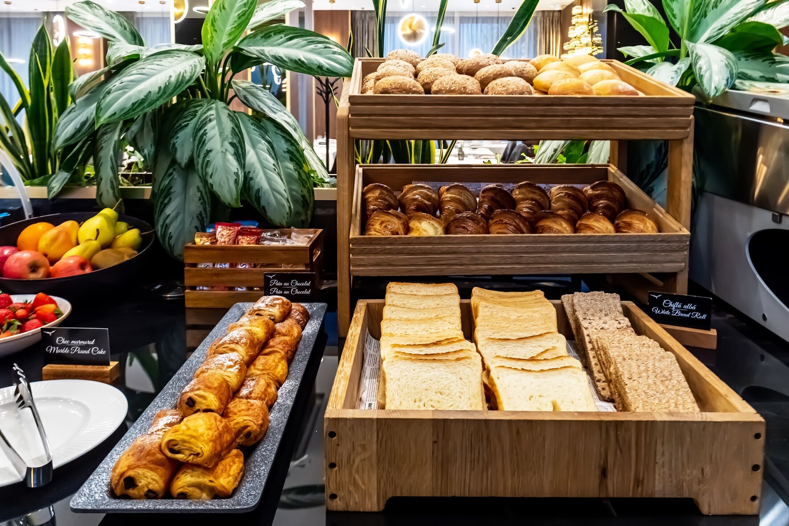 A bakery display with pastries, bread, and fruits.