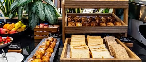A bakery display with pastries, bread, and fruits.