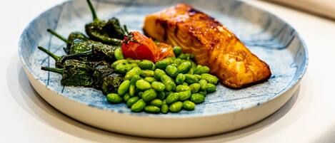 Une assiette contenant des aliments, notamment des haricots verts, des épinards et un morceau de saumon.