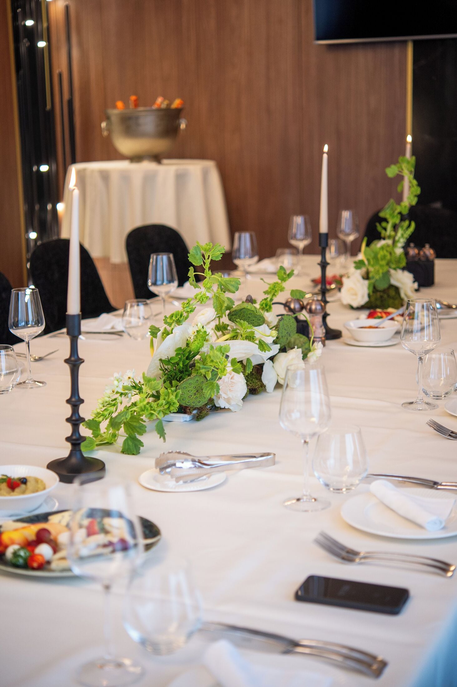 A dining table set with white tablecloth, candles, and floral centerpieces.