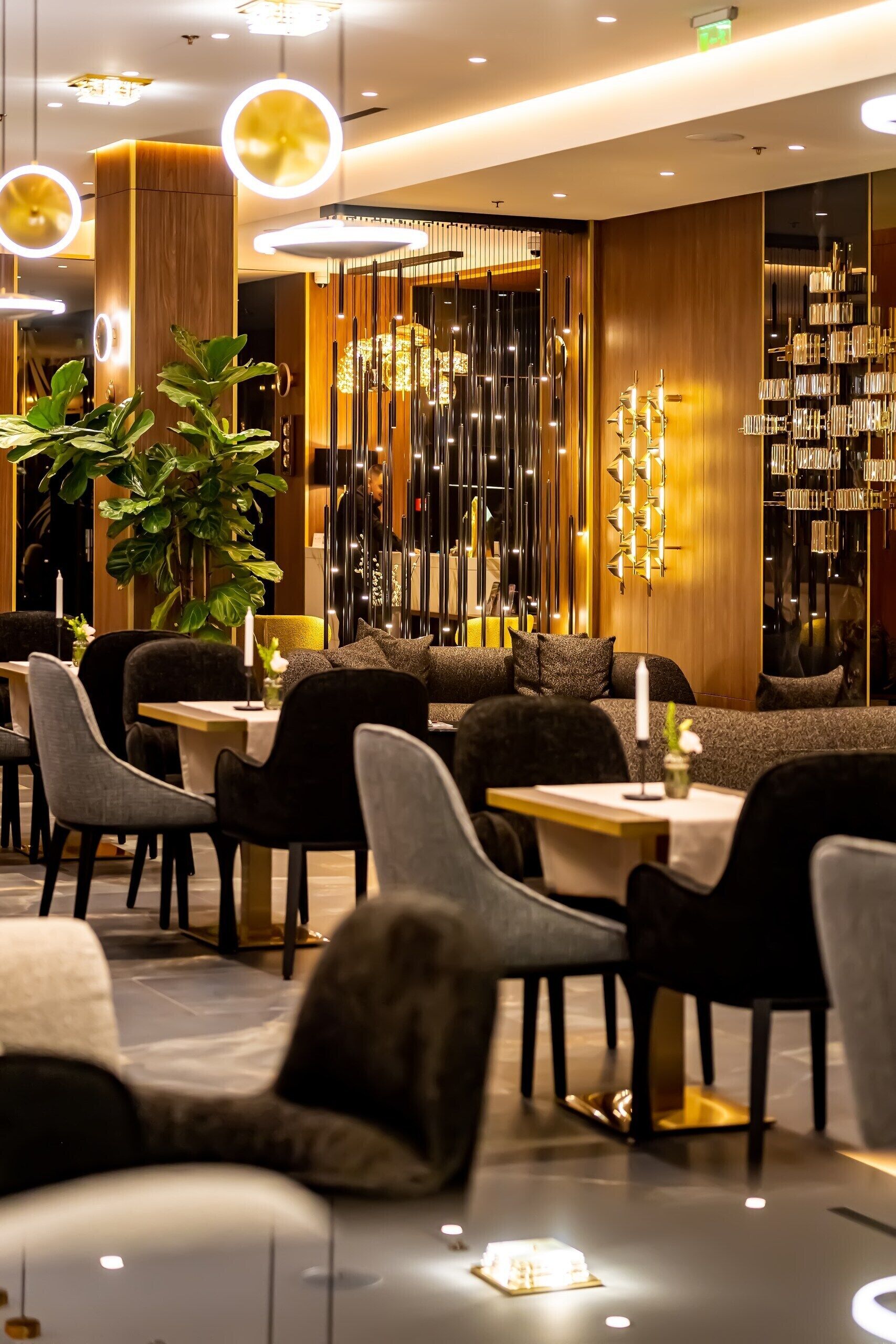 A modern dining area with round tables, dark chairs, and ambient lighting.