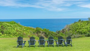 Four Adirondack chairs facing a view of the ocean. - Princeville condo with ocean views, pool and hot tub access summer deals (PRINCEVILLE)