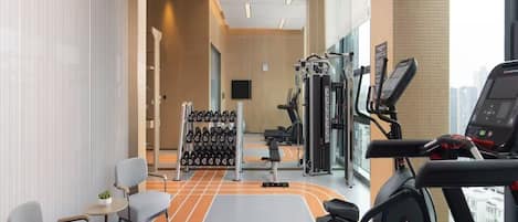 A gym with exercise equipment, a weight rack, and a track.