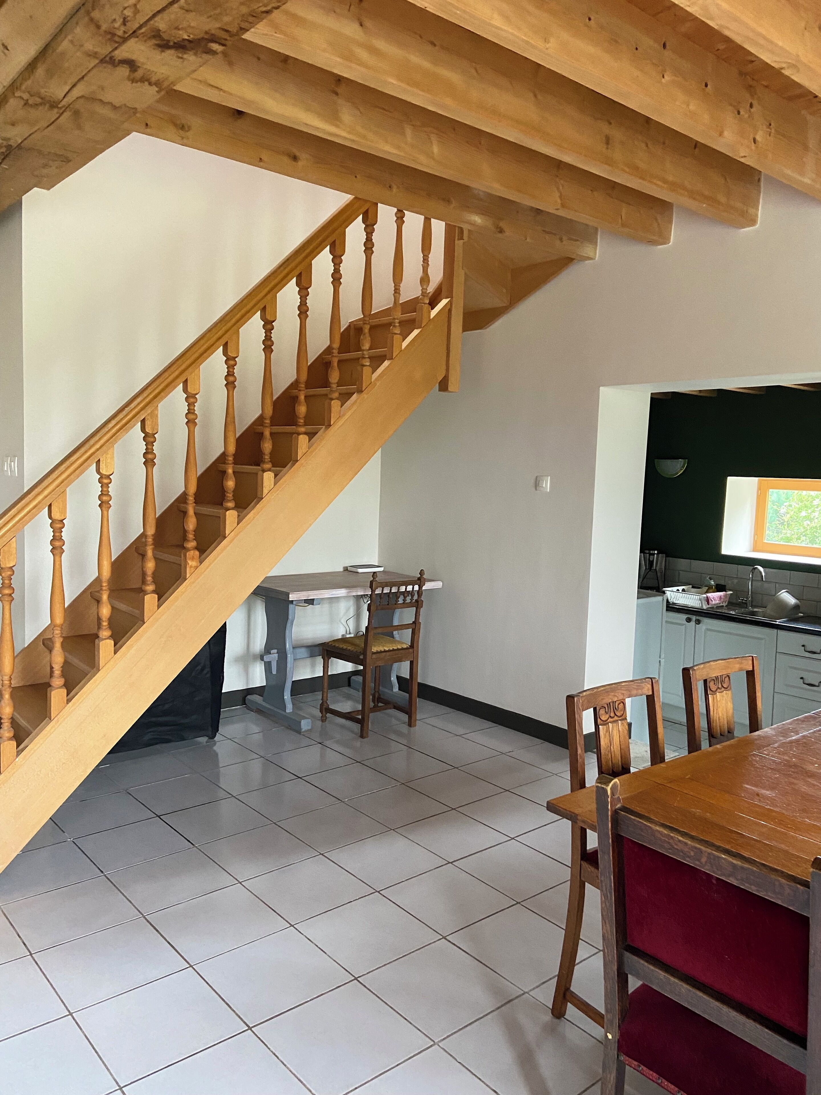 A wooden staircase leading to a dining area with a table and chairs.