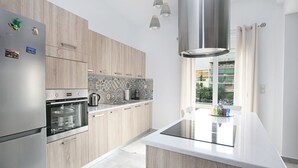 Een moderne keuken met houten kastjes, roestvrijstalen apparatuur en een groot eiland.