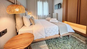 Ein modernes Schlafzimmer mit einem Bett, Nachttischen und einem großen Fenster mit Vorhängen.