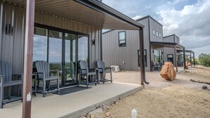 A modern building with a covered patio area featuring outdoor seating. - Willie In the Hill Country - Hacienda Amor (Johnson City)