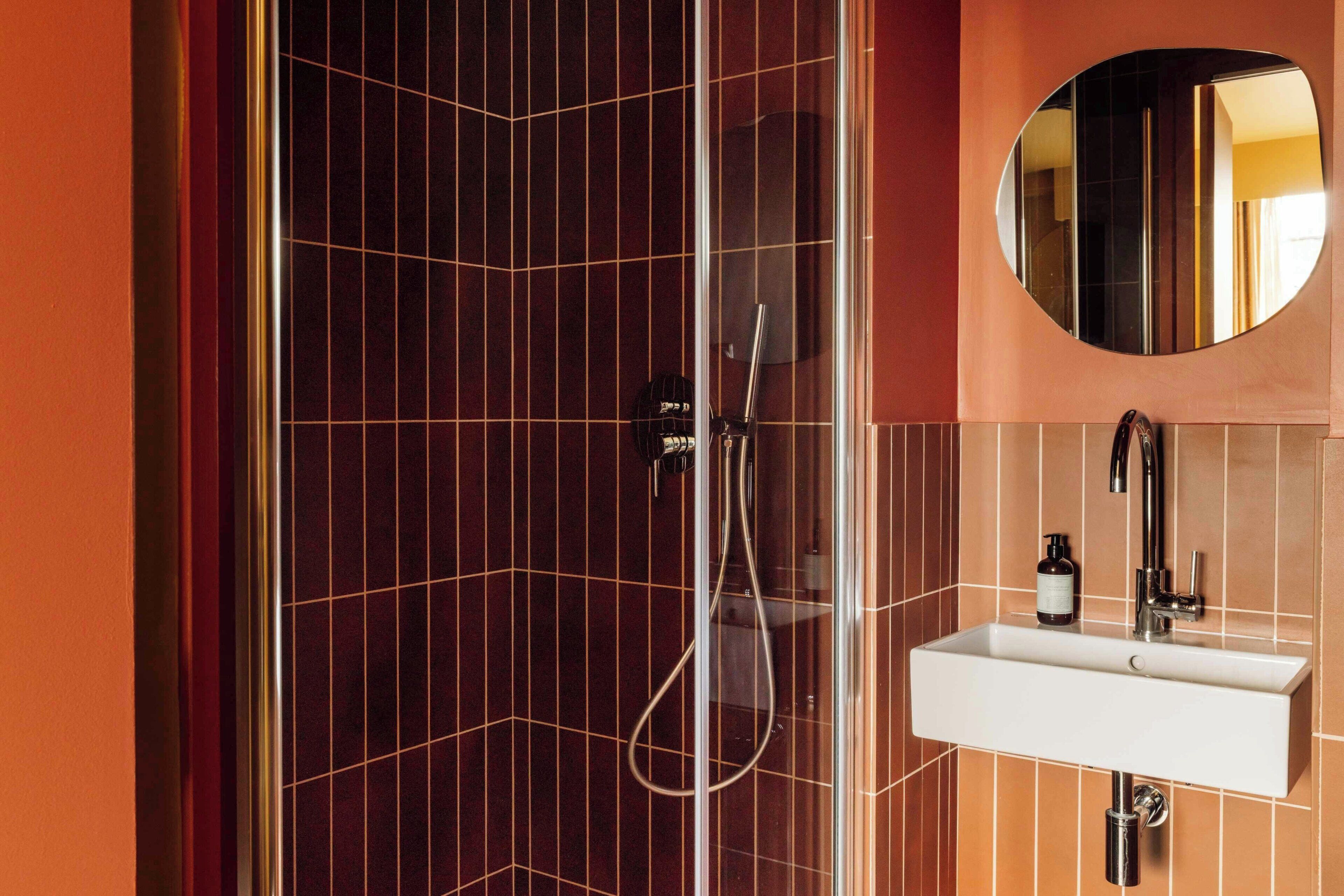 Une salle de bain avec une douche, un lavabo et un miroir.