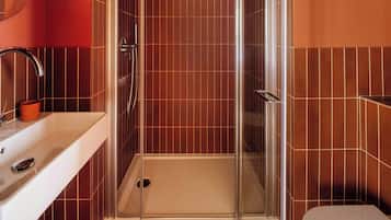A bathroom with a shower, sink, and toilet.